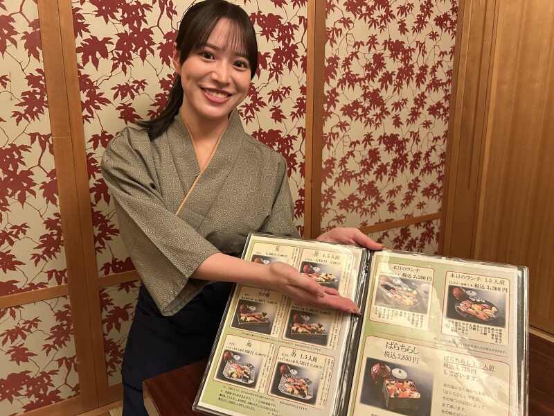 メニューをご案内するホールスタッフ